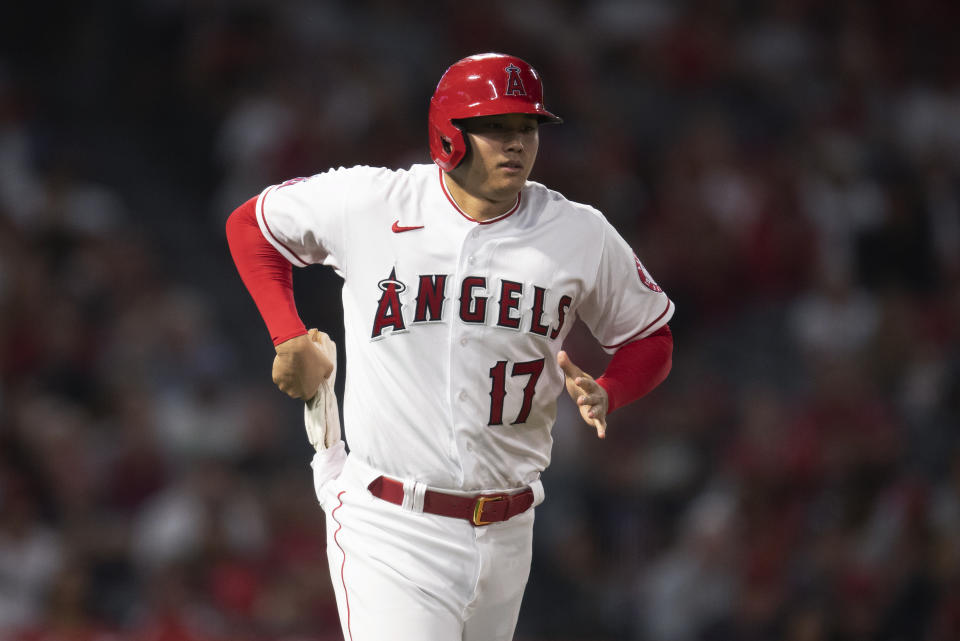 Los Angeles Angels designated hitter Shohei Ohtani pulls gloves for baserunning after drawing an intentional walk during the sixth inning of the team's baseball game against the Detroit Tigers in Anaheim, Calif., Saturday, June 19, 2021. (AP Photo/Kyusung Gong)