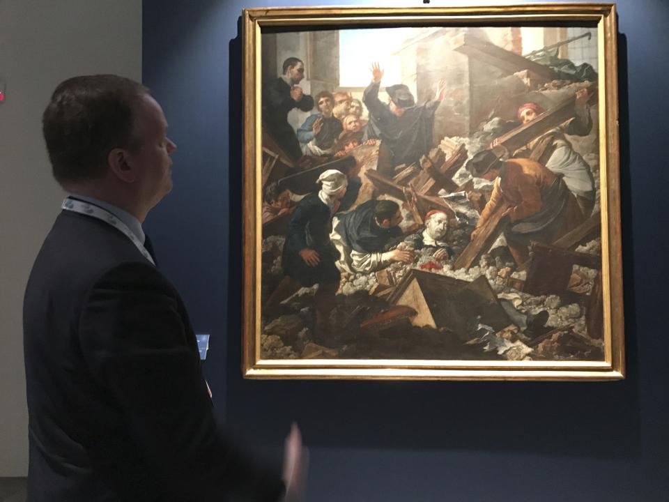 In this photo taken on Friday, March 31, 2017, Uffizi Gallery director Eike Schmidt looks at the painting ‘’The Miracle of San Filippo,’’ depicting the future pope Benedict XIII surviving an earthquake in 1688, at the Uffizi Gallery, in Florence, Italy. The Uffizi Gallery is showing solidarity with the art-rich, quake-stricken Marche region with an exhibit of treasures saved from a series of earthquakes last year. Eike Schmidt said during a walk-through Friday after the first meeting of culture ministers form the Group of Seven industrialized nations that the 29 selected works were from churches, museums and other buildings either damaged or destroyed in powerful quakes last August and October. (AP Photo/Colleen Barry)