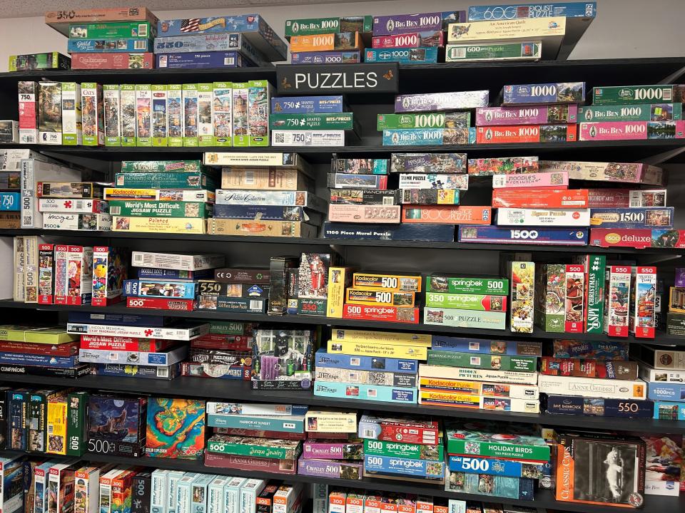 Jigsaw puzzles are a big deal at Flutterbuy Books and More. There are two walls packed with used puzzles in the back of the store.