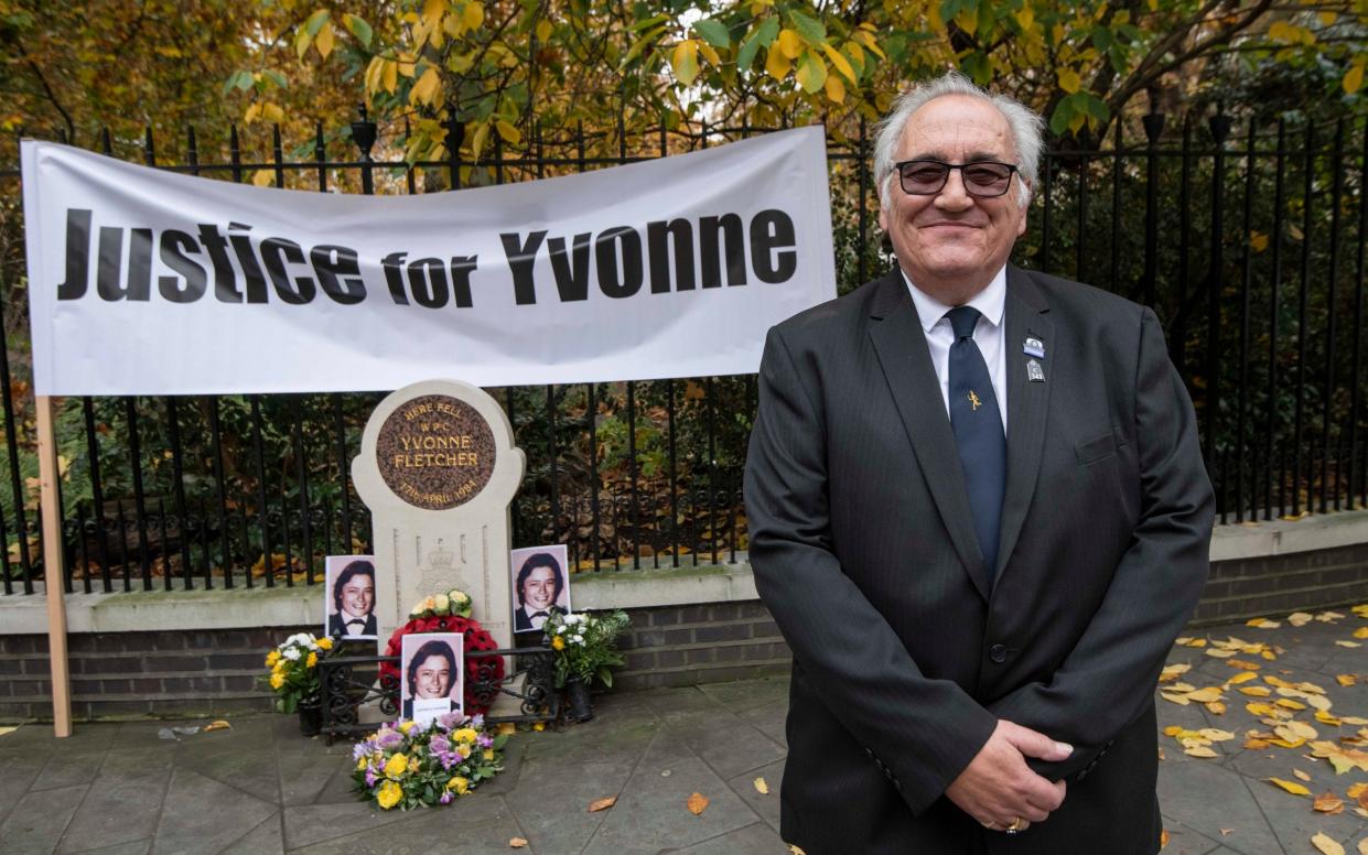 John Murray stands in front of a memorial with a sign saying 'Justice for Yvonne' - Julian Simmonds