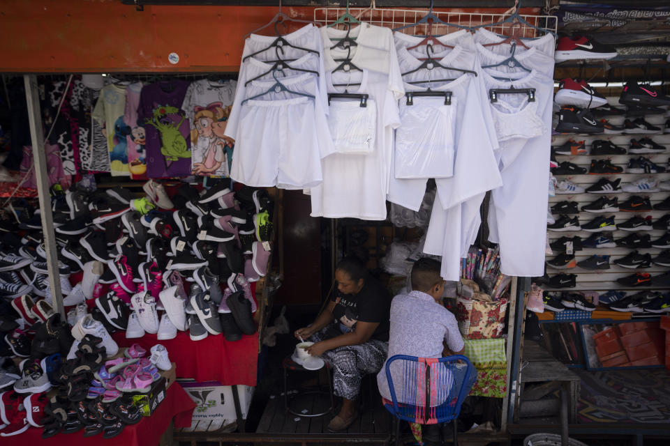 Prison whites are displayed for sale on a street stall in the historic center of San Salvador, El Salvador, Friday, Oct. 7, 2022. The arrests of more than 55,000 people under the "state of exception" have swamped the criminal justice system. At least 80 people arrested under the state of exception have succumbed without being convicted of anything. (AP Photo/Moises Castillo)