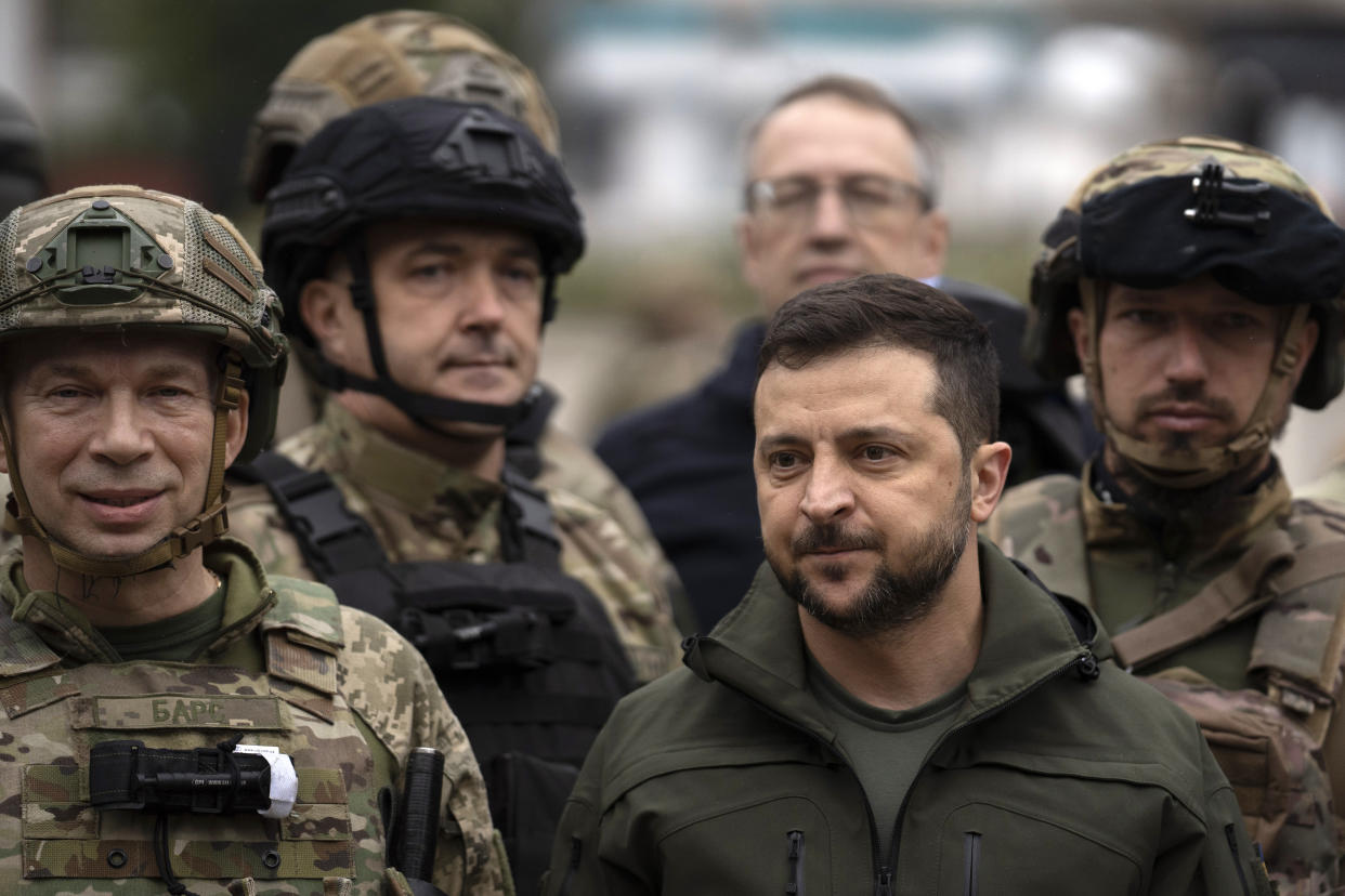 Ukrainian President Volodymyr Zelenskyy poses for a photo with soldiers after attending a national flag-raising ceremony in the freed Izium, Ukraine, Wednesday, Sept. 14, 2022. Zelenskyy visited the recently liberated city on Wednesday, greeting soldiers and thanking them for their efforts in retaking the area, as the Ukrainian flag was raised in front of the burned-out city hall building. (AP Photo/Leo Correa)