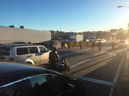 Protesters holding a pro-immigrant sign blocked lanes on the George Washington Bridge halting traffic during the morning rush hour between New Jersey and New York City, U.S., October 26, 2016. Courtesy Tidal Magazine / #decolonizethisplace/Handout via REUTERS