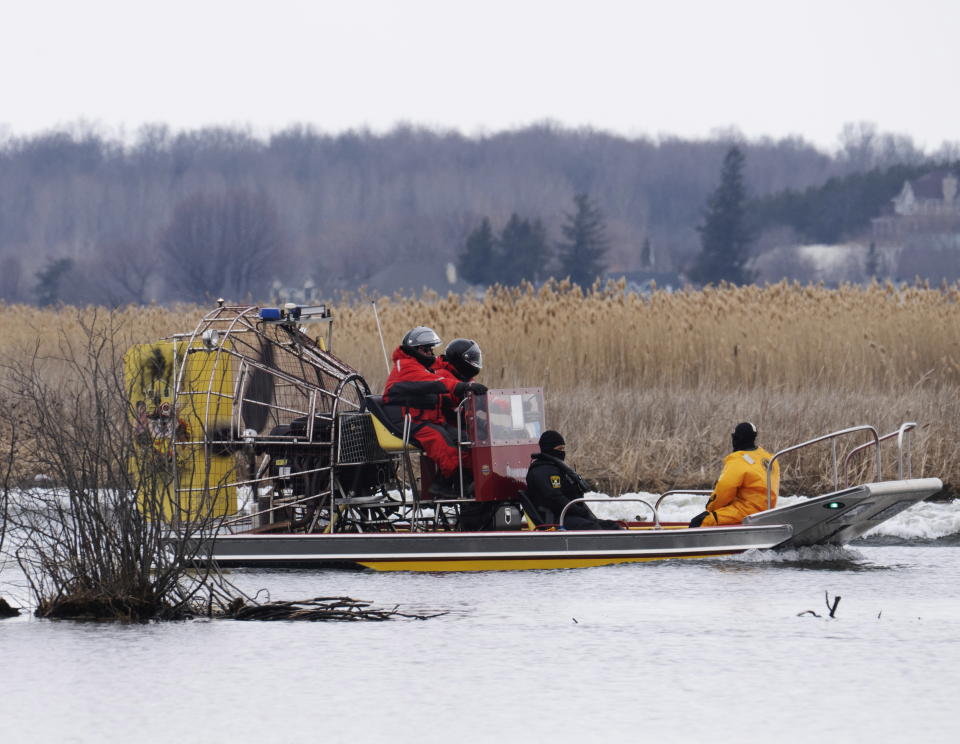 Searchers look for victims in Akwesasne, Quebec, Friday, March 31, 2023. Authorities in the Mohawk Territory of Akwesasne said Friday one child is missing after the bodies of six migrants of Indian and Romanian descent were pulled from a river that straddles the Canada-U.S. border. (Ryan Remiorz/The Canadian Press via AP)