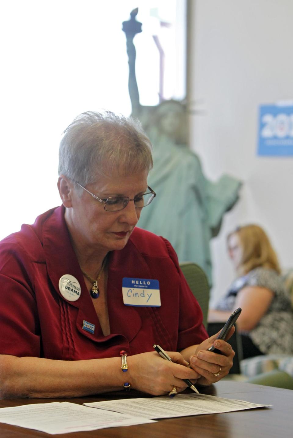 This photo taken on March 14, 2012 shows volunteer Cindy Lay working on a phone bank at a Obama campaign office in Lakewood, Colo. A handful of nurses and other volunteers took up their cell phones last week to call voters and talk up the health care overhaul. The volunteers were targeting elderly women. Holding up a sheet of talking points about the health law, campaign field director Tami Parker told about a dozen volunteers that the health care law faces a Supreme Court challenge later this month. "We need to talk about how the American Care Act helps women, especially elderly women," Parker said. The talking points ended with an argument in bold: "Some politicians want to take away these new benefits, and put insurance companies back in charge." (AP Photo/Ed Andrieski)