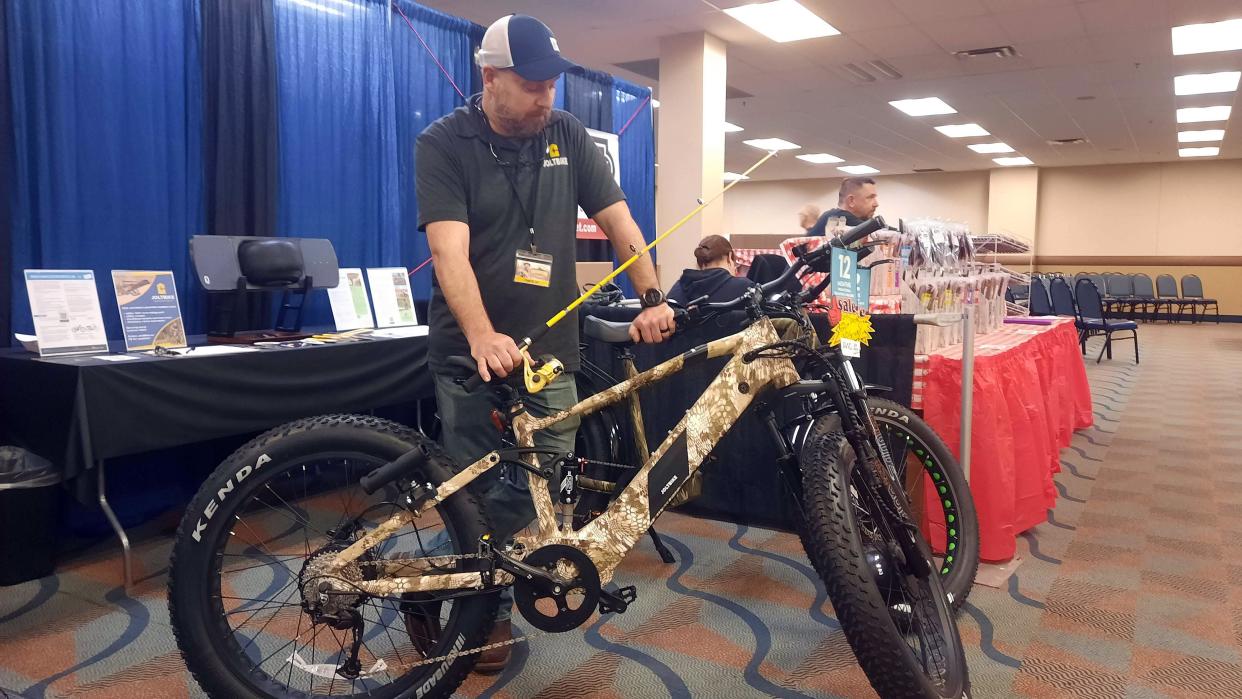 Steve Smolenski of JoltBike Electric Bike Company in Fayette County shows an e-bike that includes a fishing rod at the 2023 USA International Sportsmen’s Show and Outdoor Recreation & Travel Show in Monroeville.