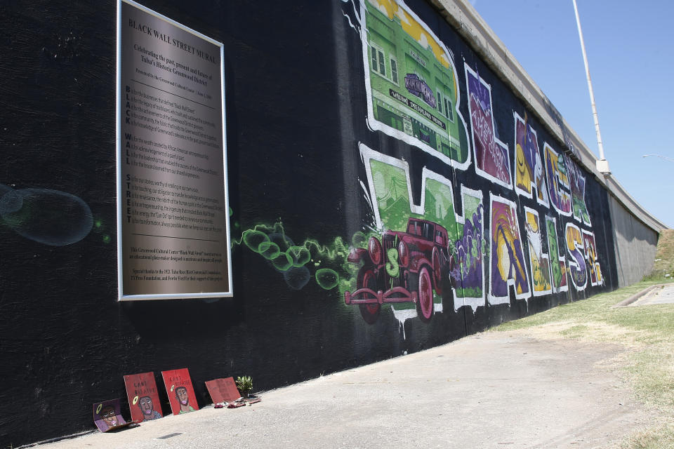 A small memorial to George Floyd is pictured at the foot of a mural of Black Wall St. in Tulsa, Okla., Monday, June 15, 2020, on the other side of what's historically the city's white-black dividing line from where President Donald Trump will rally Saturday. (AP Photo/Sue Ogrocki)