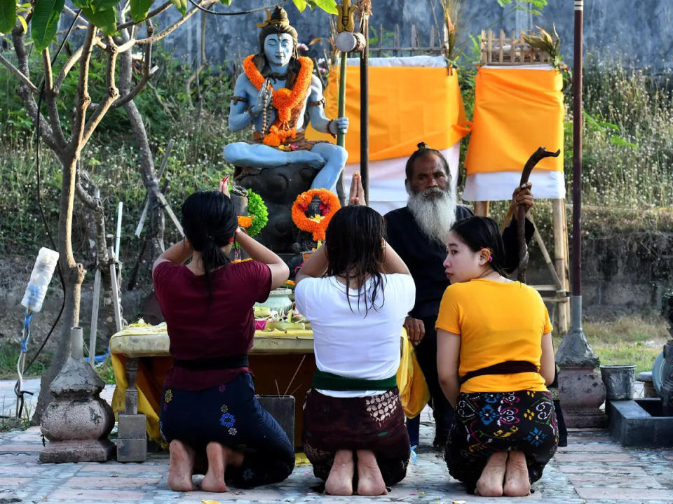 Gläubige bringen einem Priester im Pura Campuhan Windhu Sagara-Tempel am Strand von Padang Galak Gebete dar. - Copyright: Goh Chai Hin/AFP/Getty Images