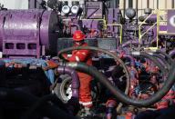 In this March 25, 2014 photo, a worker adjusts hoses during a hydraulic fracturing operation at an Encana Corp. gas well, near Mead, Colo. The first experimental use of hydraulic fracturing was in 1947, and more than 1 million U.S. oil and gas wells have been fracked since, according to the American Petroleum Institute. The National Petroleum Council estimates that up to 80 percent of natural gas wells drilled in the next decade will require hydraulic fracturing. (AP Photo/Brennan Linsley)