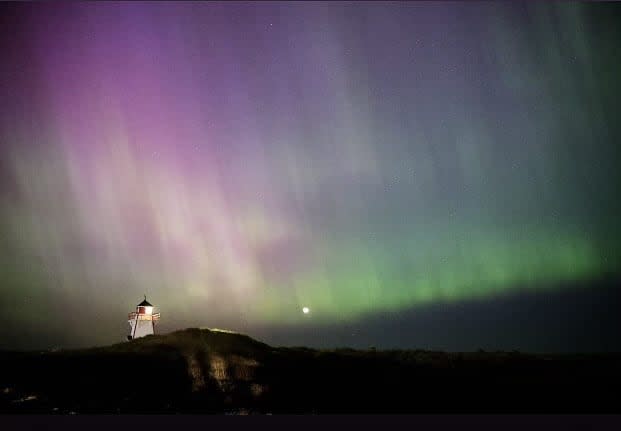 The lighthouse at Covehead is illuminated under the northern lights. More than 100 people were in the area around midnight to see the spectacle. (Beth Johnston - image credit)