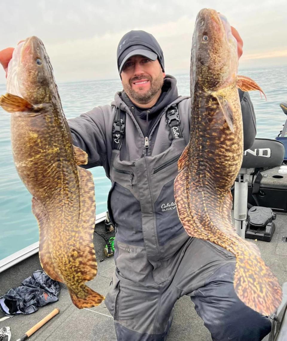 Scott Skafar holding the burbot fish he caught.