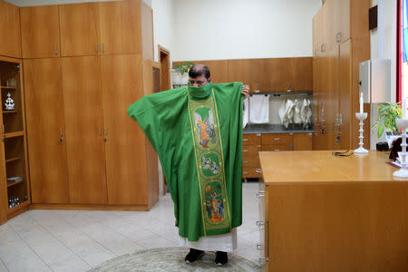 The expat bishop puts on the robe before starting the mass at St. Francis of Assisi Catholic Church in Jebel Ali, as Catholics are awaiting a historical visit by Pope Francis to the United Arab Emirates, in Dubai, UAE January 18, 2019. REUTERS/Ahmed Jadallah