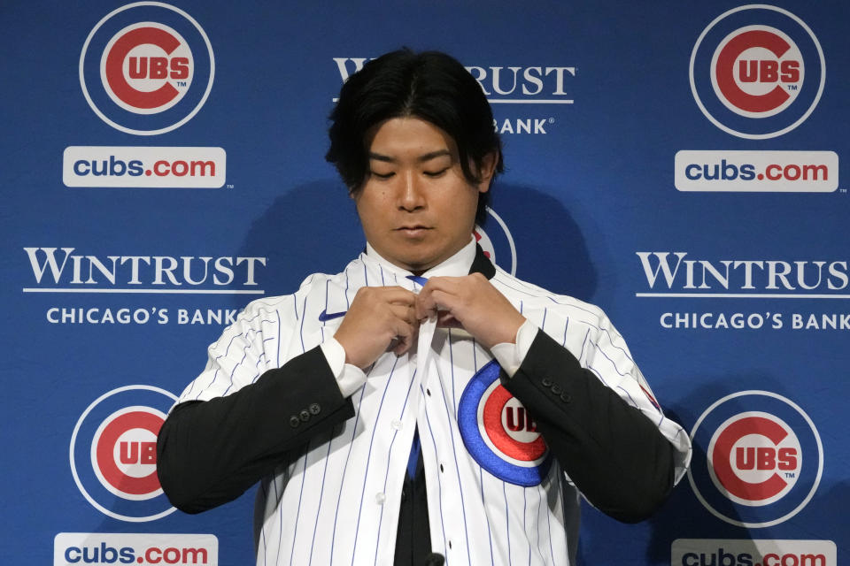 New Chicago Cubs pitcher Shōta Imanaga puts on his jersey at a news conference Friday, Jan. 12, 2024, in Chicago. The Japanese left-hander is expected to step right into the baseball team's rotation as it tries to return to the playoffs for the first time since 2020. (AP Photo/Nam Y. Huh)