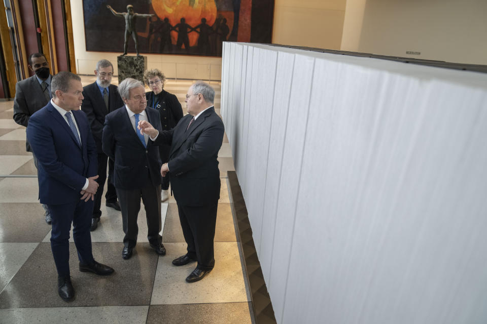 From left, Gilad Erdan, Permanent Representative of Israel to the United Nations, Antonio Guterres, United Nations Secretary General, and Dani Dayan, Chairman of Yad Vashem, browse the pages of the Yad Vashem Book of Names of Holocaust Victims Exhibit, Thursday, Jan. 26, 2023, at United Nations headquarters. (AP Photo/John Minchillo)