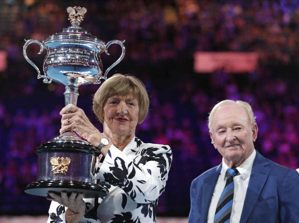 Former Australian Open champion Margaret Court holds up the womenÅfs Australian Open trophy, the Daphne Ackhurst Memorial Cup as her 50th anniversary of her Grand Slam is celebrated with Rod Laver at the Australian Open tennis championship in Melbourne, Australia, Monday, Jan. 27, 2020. (AP Photo/Lee Jin-man)