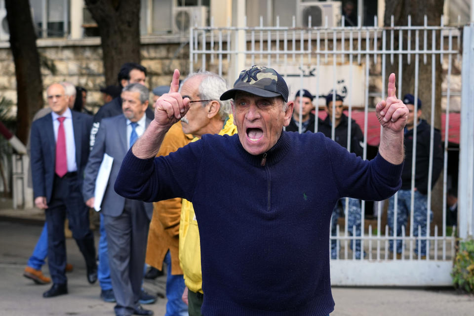 A Lebanese man chants slogans against Riad Salameh, Lebanon's Central Bank governor, in front of the Justice Palace in Beirut, Lebanon, Thursday, March 16, 2023. Lebanon's embattled Central Bank chief appeared Thursday for questioning for the first time before a European legal team visiting Beirut in a money-laundering probe linked to the governor. (AP Photo/Bilal Hussein)