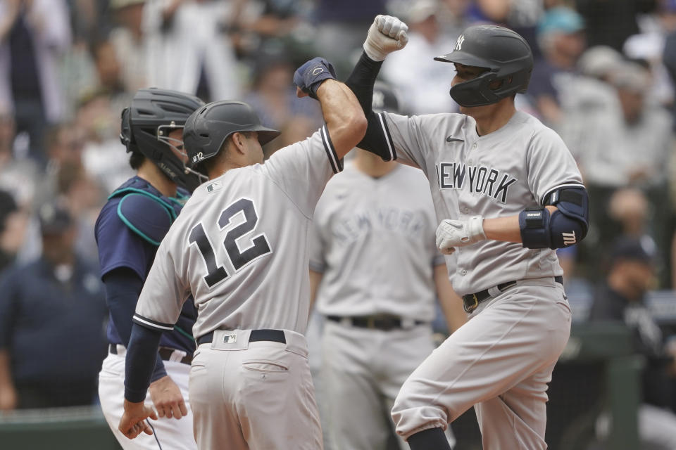 New York Yankees' Kyle Higashioka, right, greets Isiah Kiner-Falefa (12) at the plate after Higashioka hit a two-run home run to score Kiner-Falefa during the seventh inning of a baseball game, Wednesday, Aug. 10, 2022, in Seattle. (AP Photo/Ted S. Warren)