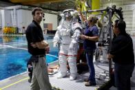 NASA Commercial Crew astronaut Sunita Williams is helped to get into her space suit at NASA's Neutral Buoyancy Laboratory (NBL) training facility near the Johnson Space Center in Houston