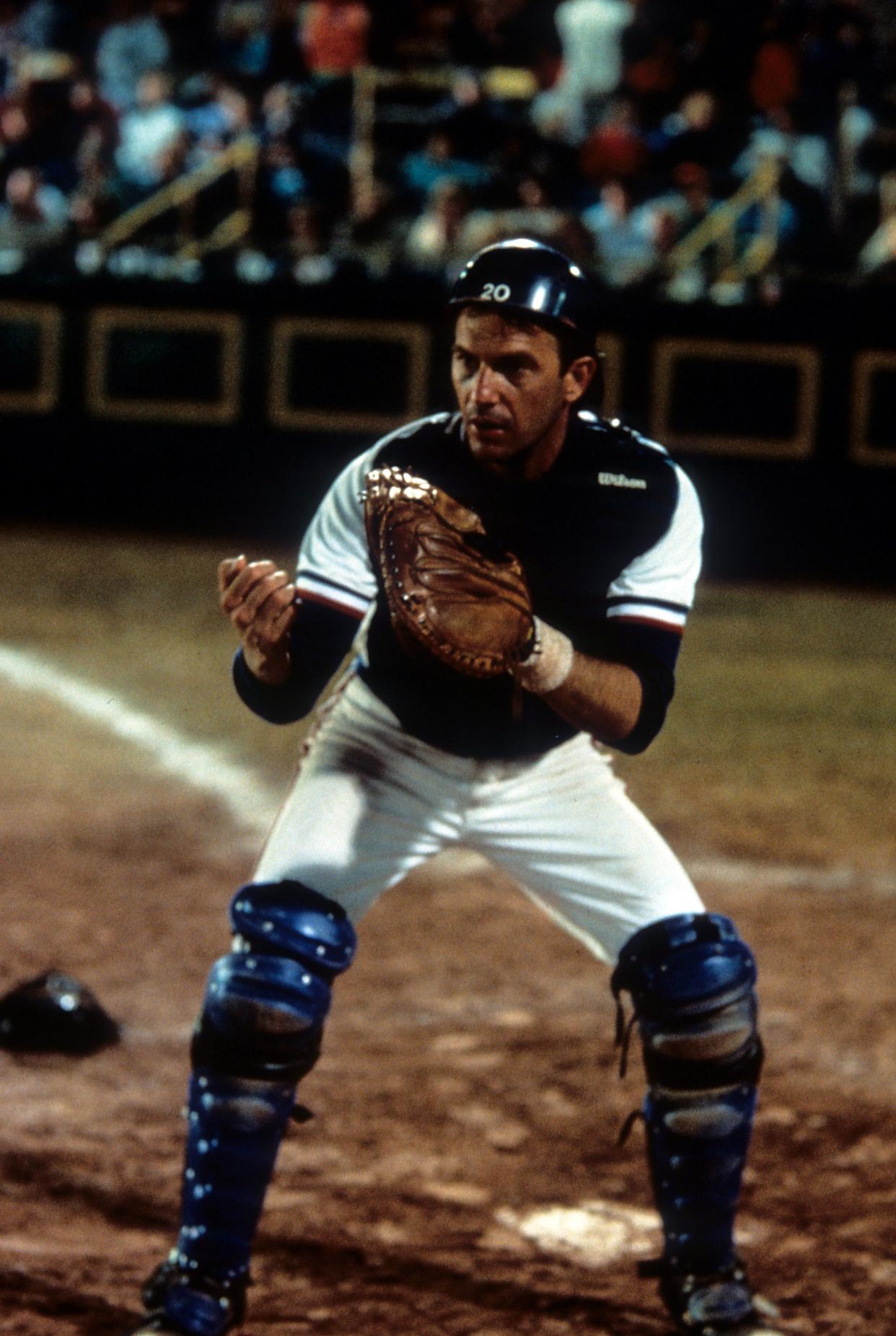 Kevin Costner playing catcher on a baseball team in a scene from the film 'Bull Durham'