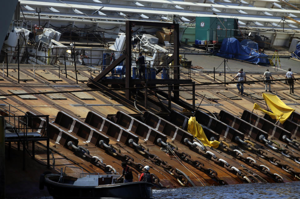 The Costa Concordia cruise ship lies on its side in the Tuscan Island of Isola del Giglio, Monday, July 15, 2013. Salvage crews are working against time to right and remove the shipwrecked Costa Concordia cruise ship, which is steadily compressing down on itself from sheer weight onto its granite seabed perch off the Tuscan island of Giglio. Salvage master Nick Sloane said Monday that the Concordia has compressed some 3 meters (10 feet) since it came to rest on the rocks Jan. 13, 2012 after ramming a jagged reef during a stunt ordered by the captain that cost the lives of 32 people. (AP Photo/Gregorio Borgia)