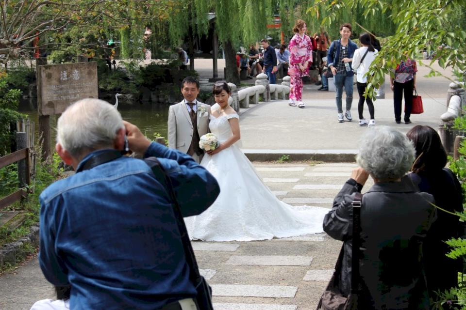 作者認為，婚姻是真摯承諾一起摸索未來，或許一生一世不容易，但過程也得雙方真正負起責任。圖為京都的公園裡，老夫婦滿心喜悅地為自己的兒孫拍婚紗照，或許也盼望著他們白頭到老。示意圖：沈聰榮