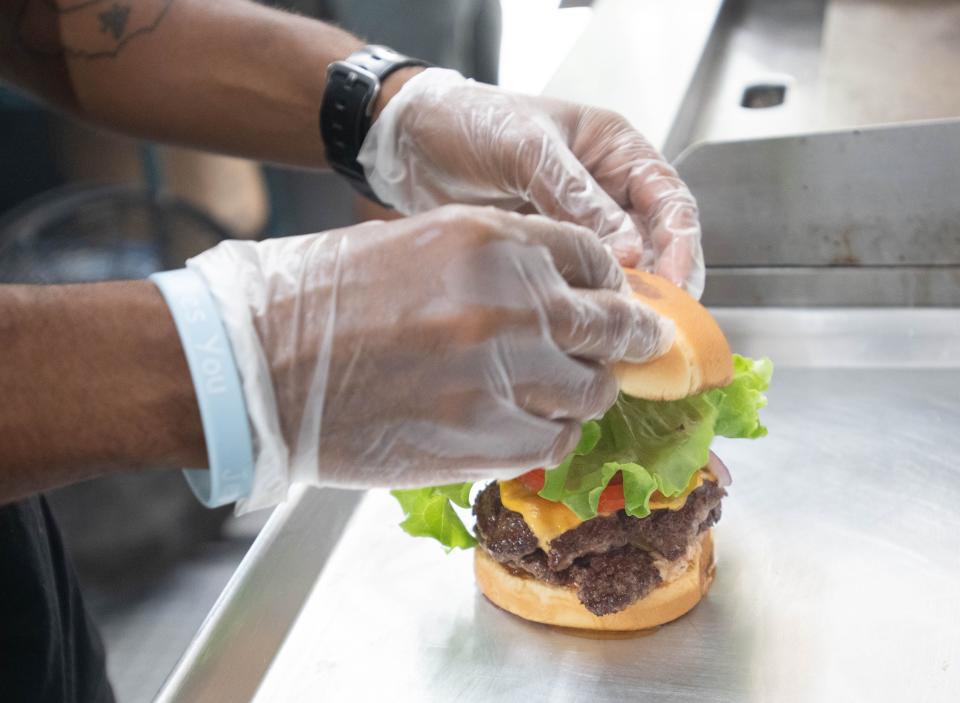 Co-owner Kyle Smith prepares a Proper Burger at the Proper Burger food truck at Vinyl Music Hall’s B Side outdoor venue along Garden Street in downtown Pensacola on Wednesday, Aug. 30, 2023.