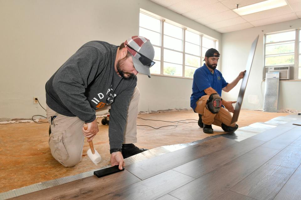 Mark Brock and Jeremy Arthur install flooring in the new Ruth Lovejoy Day Center at Crestview Manor. The 840-square-foot facility will be unveiled at the manor's 40th anniversary celebration on Saturday. The day center will allow Crestview residents to drop off family members for whom they are caring for the day to be supervised by manor staff, allowing the family member time to take care of their own needs.