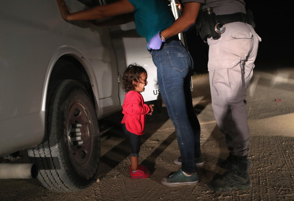 A two-year-old Honduran asylum seeker cries as her mother is searched and detained near the U.S.-Mexico border earlier this month in McAllen, Texas. (John Moore via Getty Images)