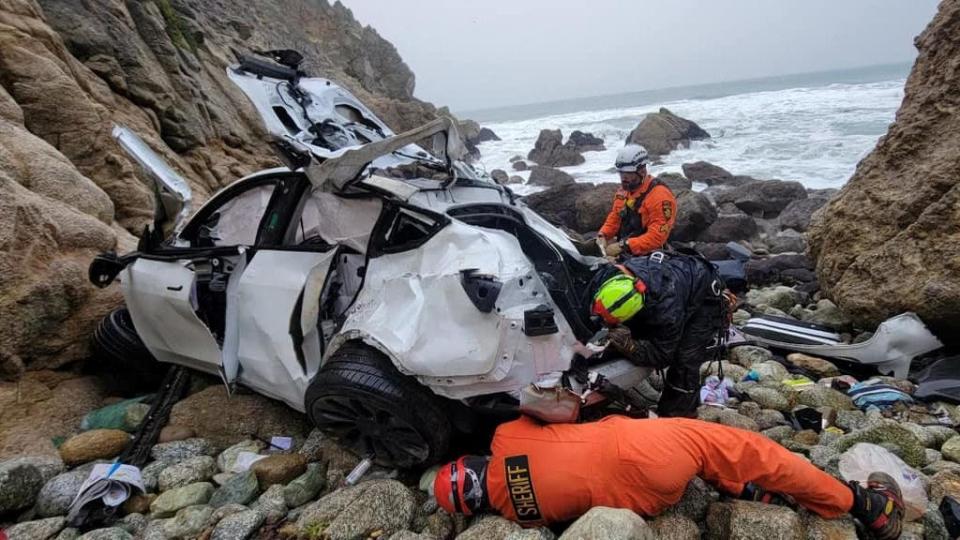 Rescuers work on retrieving a destroyed Tesla sedan that had plunged off a cliff in an area called the Devil's Slide in San Mateo County, California January 2, 2023.