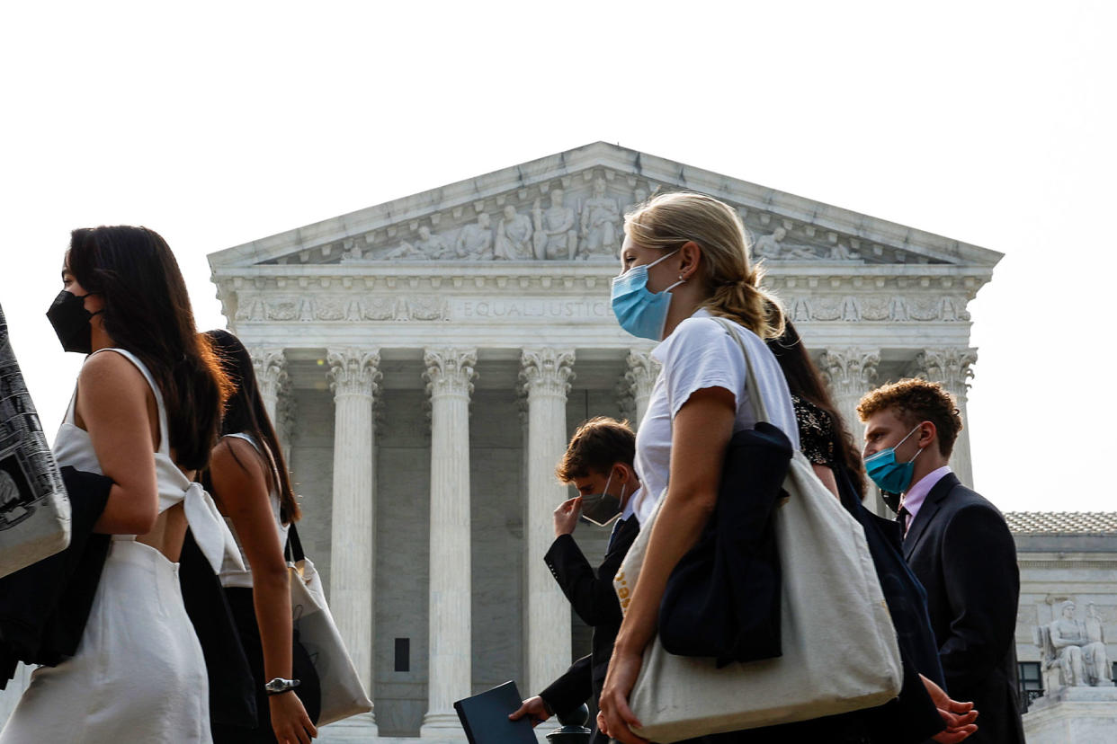 A group of people wear face masks as they walk past the U.S. Supreme Court Building on June 29, 2023 in Washington, DC. Anna Moneymaker/Getty Images