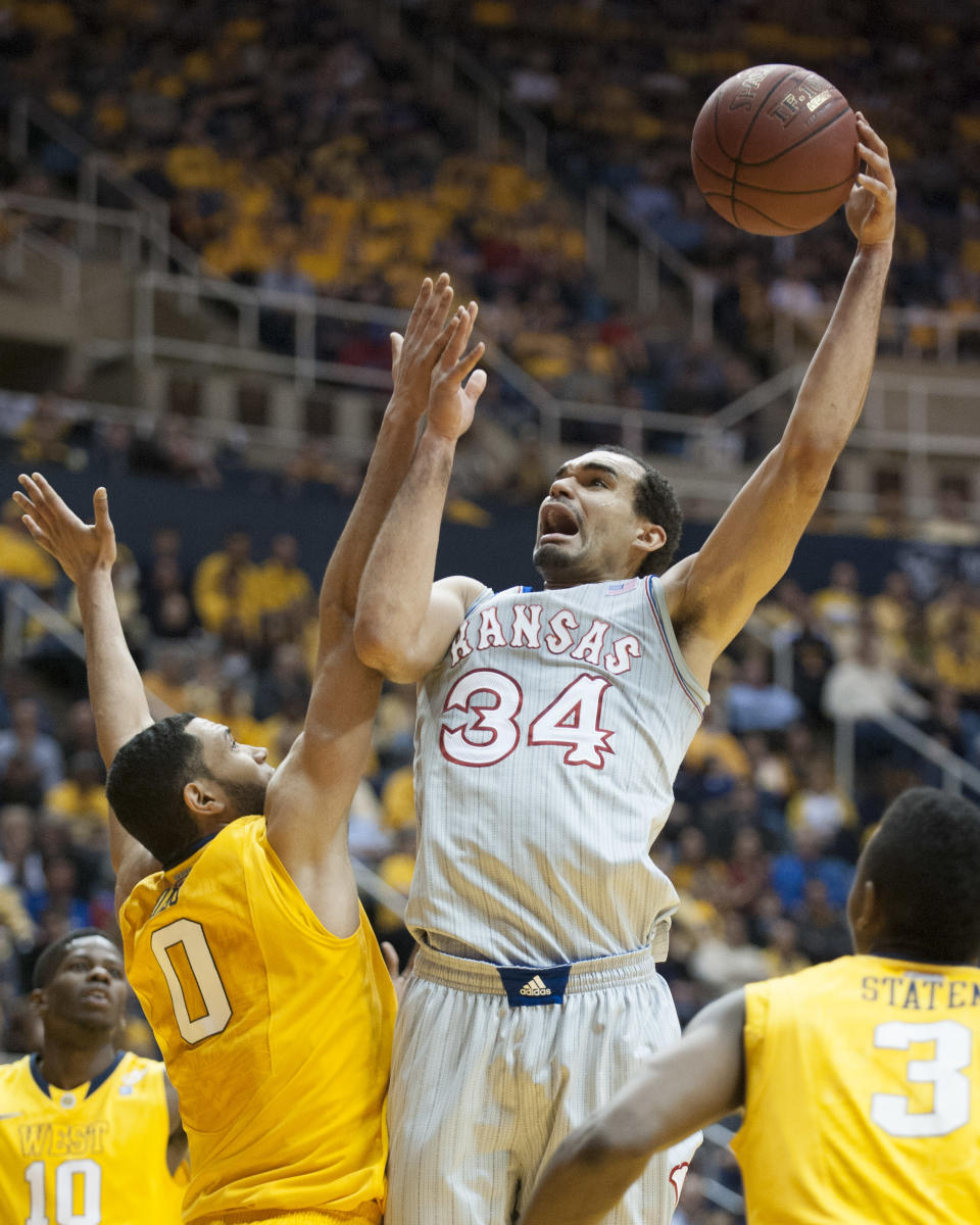 Kansas' Perry Ellis, right, shoots over West Virginia's Remi Dibo during the first half of an NCAA college basketball game Saturday, March 8, 2014, in Morgantown, W.Va. (AP Photo/Andrew Ferguson)