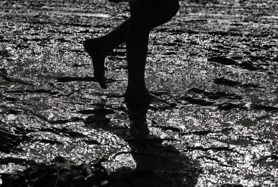 A man walks through thick ash on a road from Taal volcano in Lemery, Batangas, southern Philippines on Monday, Jan. 13, 2020. (AP Photo/Aaron Favila)