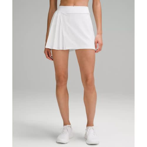 model wearing asymmetrical tennis skirt in white