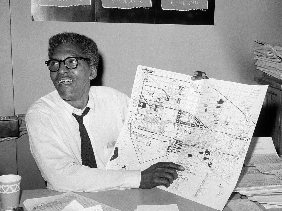 Black and white photo of Bayard Rustin holding a map for the March on Washington.