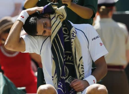 Novak Djokovic of Serbia stretches during a break between games of his match against Richard Gasquet of France at the Wimbledon Tennis Championships in London, July 10, 2015. REUTERS/Suzanne Plunkett