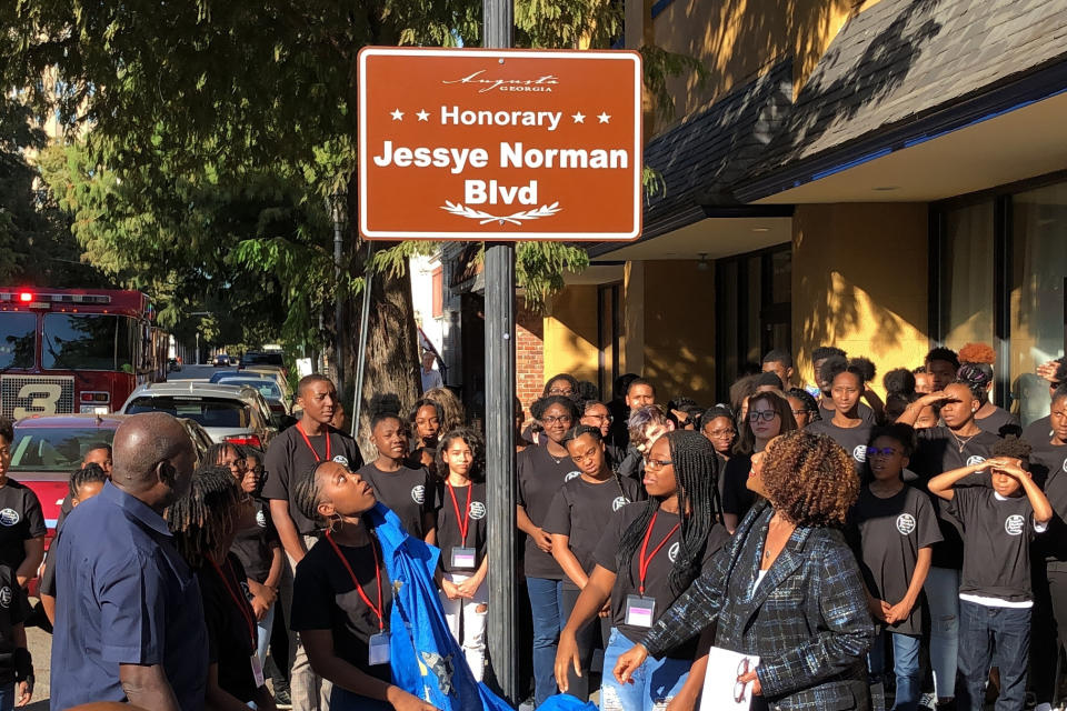 Students at the Jessye Norman School of the Arts unveil a sign naming the street outside the school in honor of the late opera star, Friday, Oct. 11, 2019, in Augusta, Ga. Norman, who won five Grammy awards including a lifetime achievement honor in her distinguished career, died on Sept. 30, at age 74. Her funeral is slated for Saturday and a benefit concert for the school follows on Sunday. (AP Photo/Jeffrey Collins)