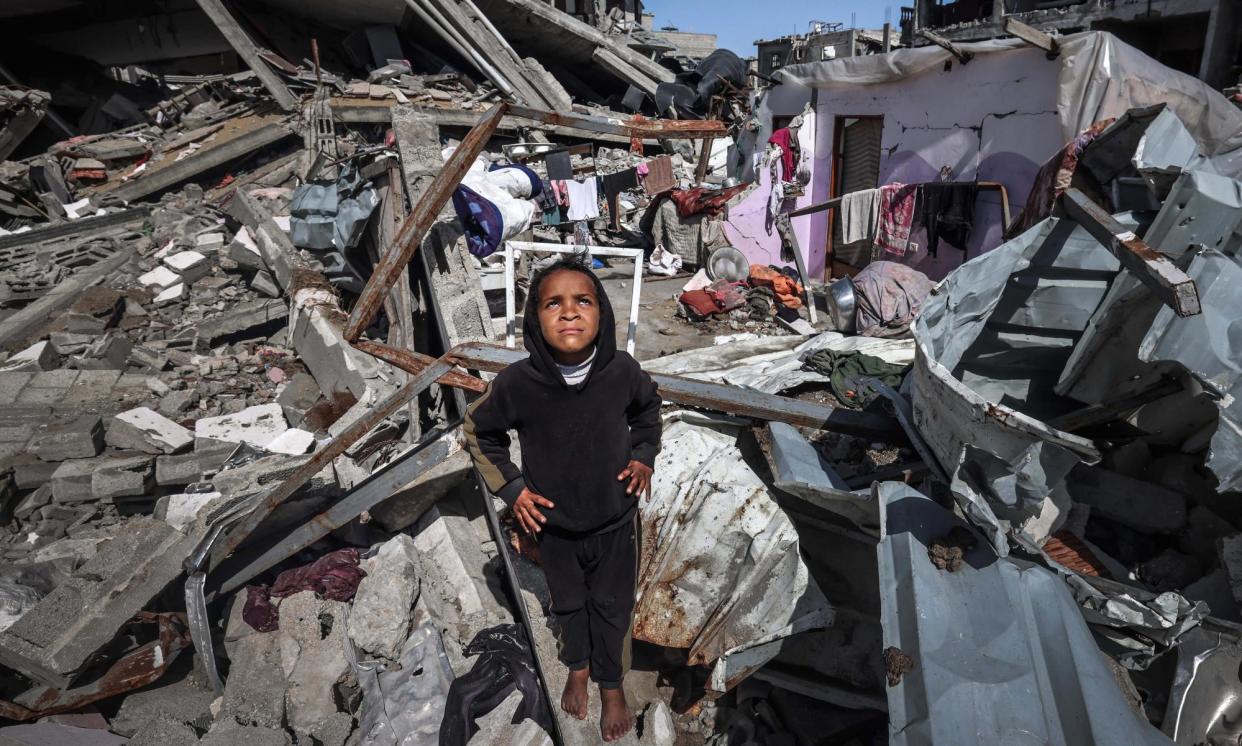 <span>A Palestinian girl looks at a military drone as she stands on the rubble of destroyed houses in the Rafah refugee camp on Thursday.</span><span>Photograph: Mohammed Abed/AFP/Getty Images</span>