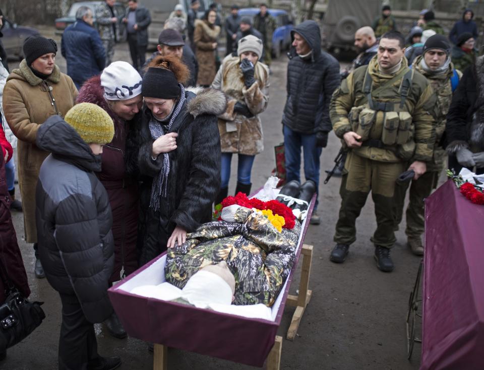 FILE - In this Feb. 5, 2015, file photo, relatives of a pro-Russian rebel fighter killed during fighting against Ukrainian government forces, mourn during his funeral in Vuhlehirsk, Donetsk region, eastern Ukraine, after the separatists recently burst through government lines in Vuhlehirsk. Tensions have risen in the conflict in eastern Ukraine, with growing violations of a cease-fire and a massive Russian military buildup on its side of the border. Ukraine and the West have become increasingly worried about the presence of more Russian troops and urged Moscow to pull them back. (AP Photo/Vadim Braydov, File)