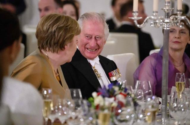 King Charles laughs as he talks to Angela Merkel