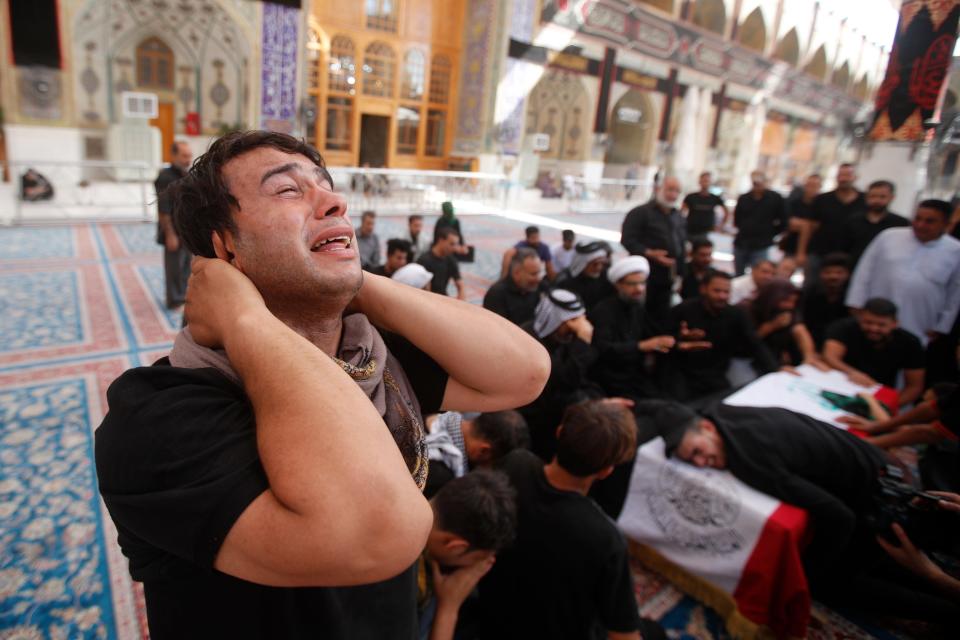 Relatives attend a funeral of a man killed during clashes with security in Baghdad during his funeral in Najaf, Iraq, Tuesday, Aug. 30, 2022.