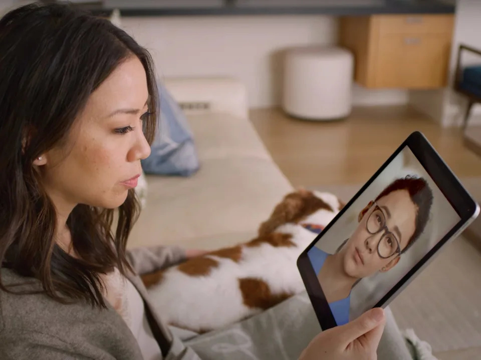 여성이 강아지와 함께 소파에 앉아 아이패드를 통해 AI 간호사와 대화하는 엔비디아와 히포크라테스 AI 영상