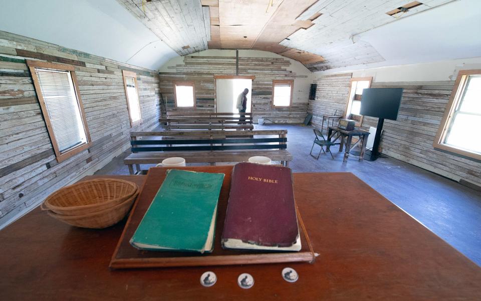 Floyd Bailey, curator of the Mississippi John Hurt landmarks, walks through St. James Missionary Baptist Church in Carroll County on Friday. The funeral for blues singer, songwriter and guitarist John Hurt was held at St. James. On the pulpit sits a Bible, a Baptist hymnal and tokens of a man playing guitar.