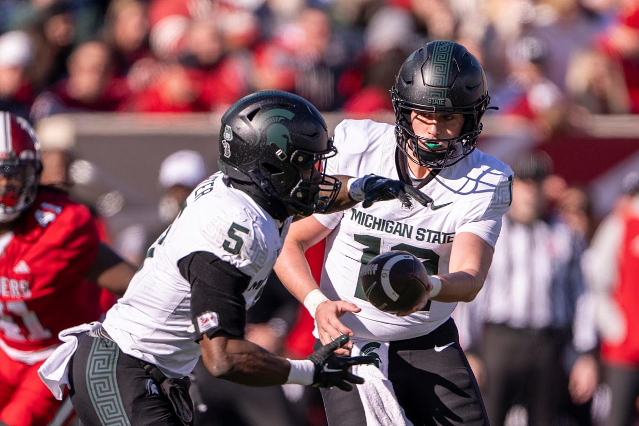 Michigan State quarterback Katin Houser hands there ball off running back Nathan Carter during the second quarter on Saturday, Nov. 18, 2023, in Bloomington, Indiana.