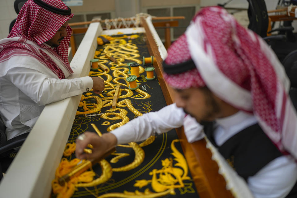 Saudi men embroiders Islamic calligraphy, using either pure silver threads or silver threads plated with gold, during the final stages in the preparation of a drape, or Kiswa, that covers the Kaaba, a cube-shaped structure at the heart the Grand Mosque, at the Kiswa factory in Mecca, Saudi Arabia, Thursday, June 13, 2024. (AP Photo/Rafiq Maqbool)