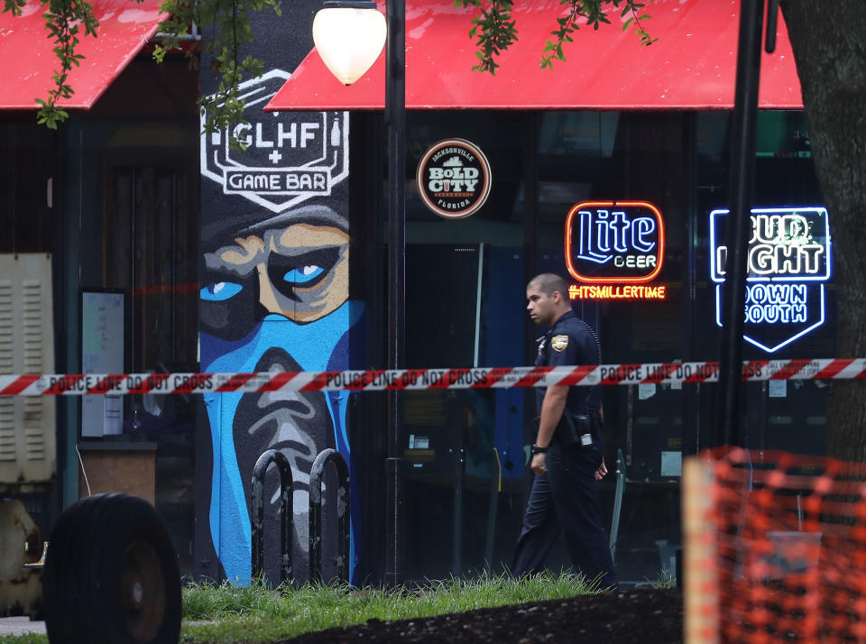 A Jacksonville Sheriff officer walks past the GLHF Game Bar where gamers Taylor Robertson and Elijah Clayton were killed on Sunday. (Getty Images)