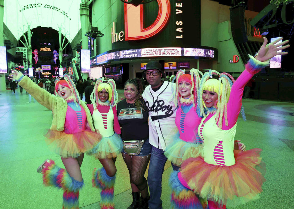 Derrick Westmorelandm of Houstonm and Alisha McCordm of Memphis, Tenn., pose with, from left, Melissa Dillon, Preeti Saha, Lydia Penn and Uli Auliani, all of Las Vegas, during the New Year's Eve party at the Fremont Street Experience in downtown Las Vegas on Friday, Dec. 31, 2021. (K.M. Cannon/Las Vegas Review-Journal via AP)