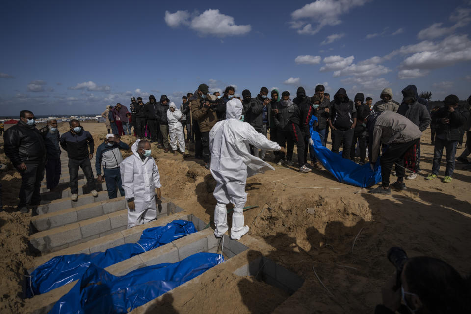 Palestinians bury the bodies of people who were killed in fighting with Israel and returned to Gaza by the Israeli military, during a mass funeral in Rafah, Gaza Strip, Tuesday, Jan. 30, 2024. (AP Photo/Fatima Shbair)