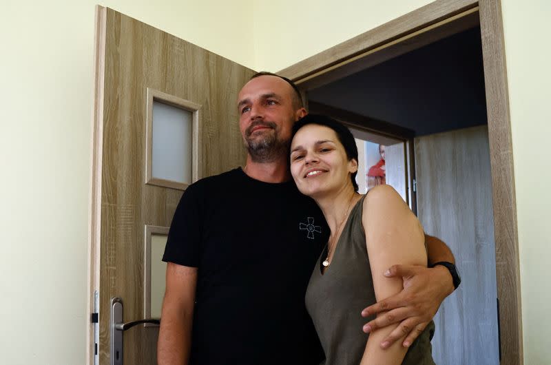 Ukrainian soldier Dovzhenko, 41 holds his wife Aleksandra during an interview for Reuters at his home in Wroclaw