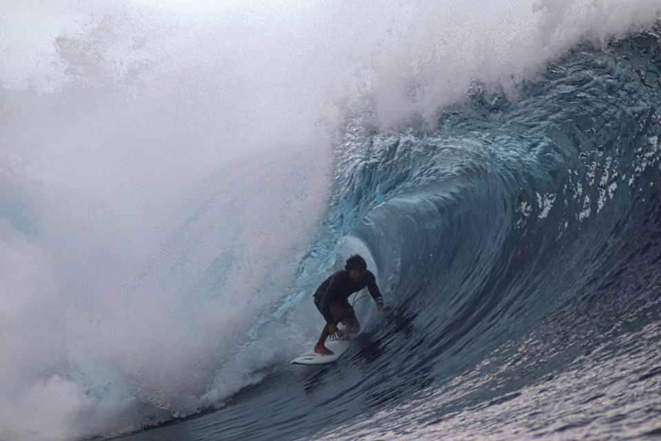 FILE - A surfer rides a wave during the Tahiti Pro surfing competition, a test event for the Paris 2024 Olympics Games in Teahupo'o, French Polynesia in the Pacific Ocean, Friday, Aug. 11, 2023. Organizers of next year's Paris Olympics are scaling back the metal tower they plan to build at the picture-perfect surfing venue in Tahiti, bowing to concerns on the French Polynesian island about damage to sea-life and its majestic Teahupo’o wave. (AP Photo/Esther Cuneo, File)