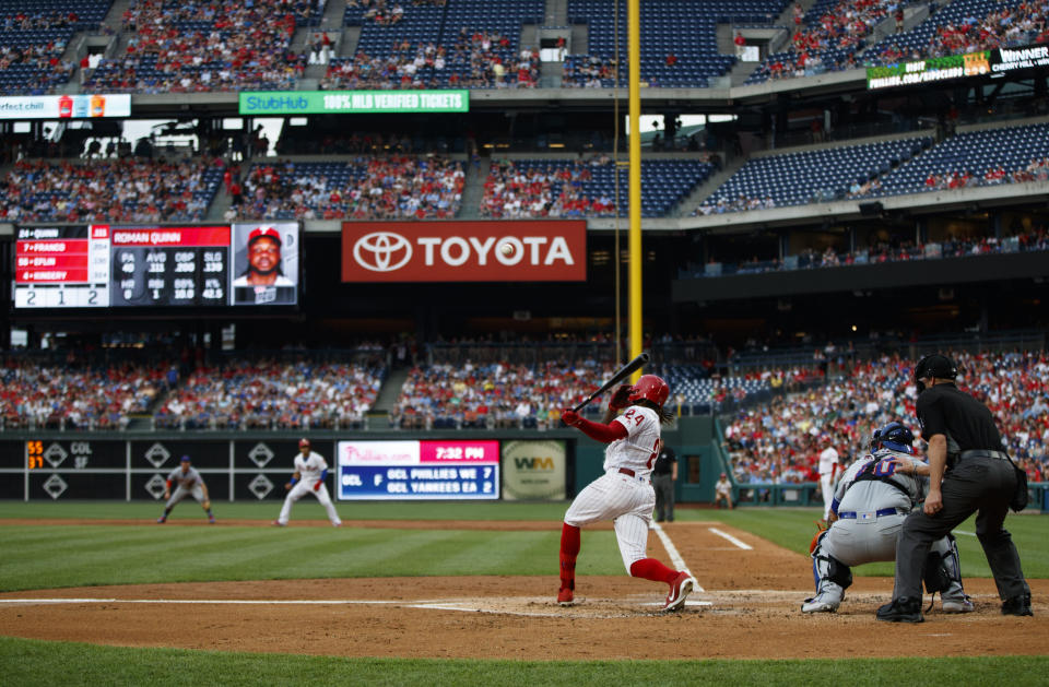 Philadelphia Phillies' Roman Quinn, left, follows through after hitting a run-scoring single off New York Mets starting pitcher Steven Matz during the first inning of a baseball game, Monday, June 24, 2019, in Philadelphia. (AP Photo/Matt Slocum)